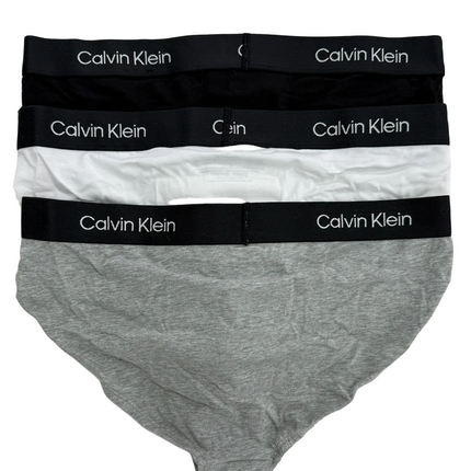 Three pairs of Calvin Klein underwear in gray, white, and black on a light gray background.